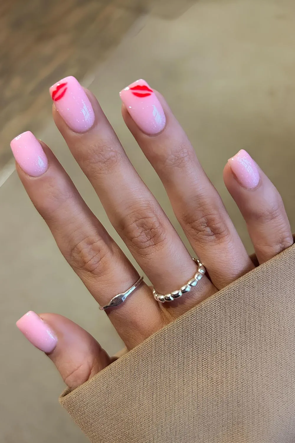 Shimmery pink nails with red kiss details