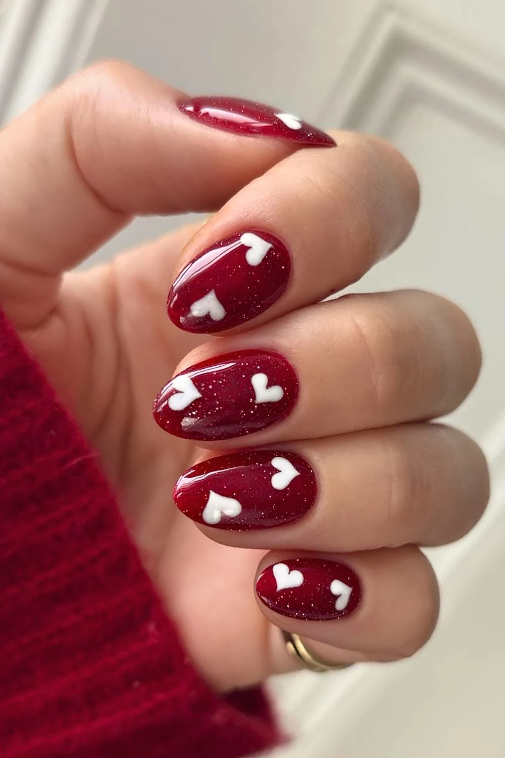 Shimmery red nails with white hearts