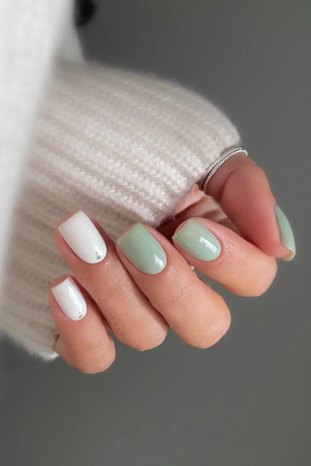 Soft green and white nails with dot accent