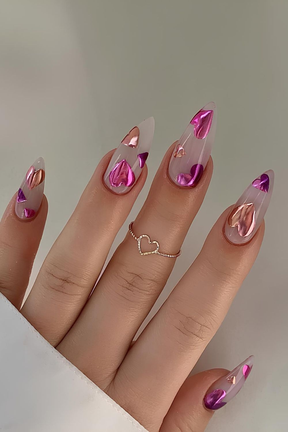 Soft milky nails with chrome heart accents in purple, pink and rose gold