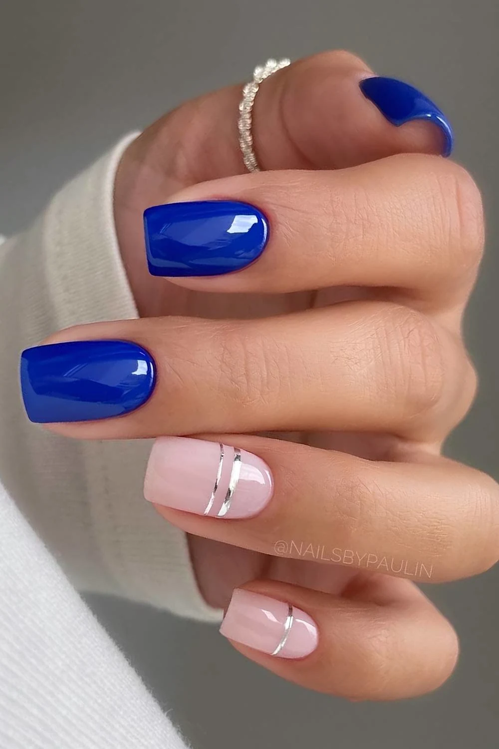 Vibrant blue nails with silver stripe art