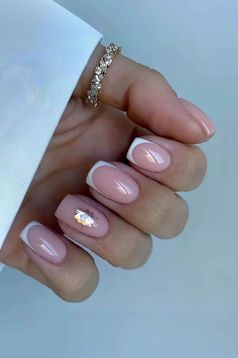 White French tips with golden foil and heart accent