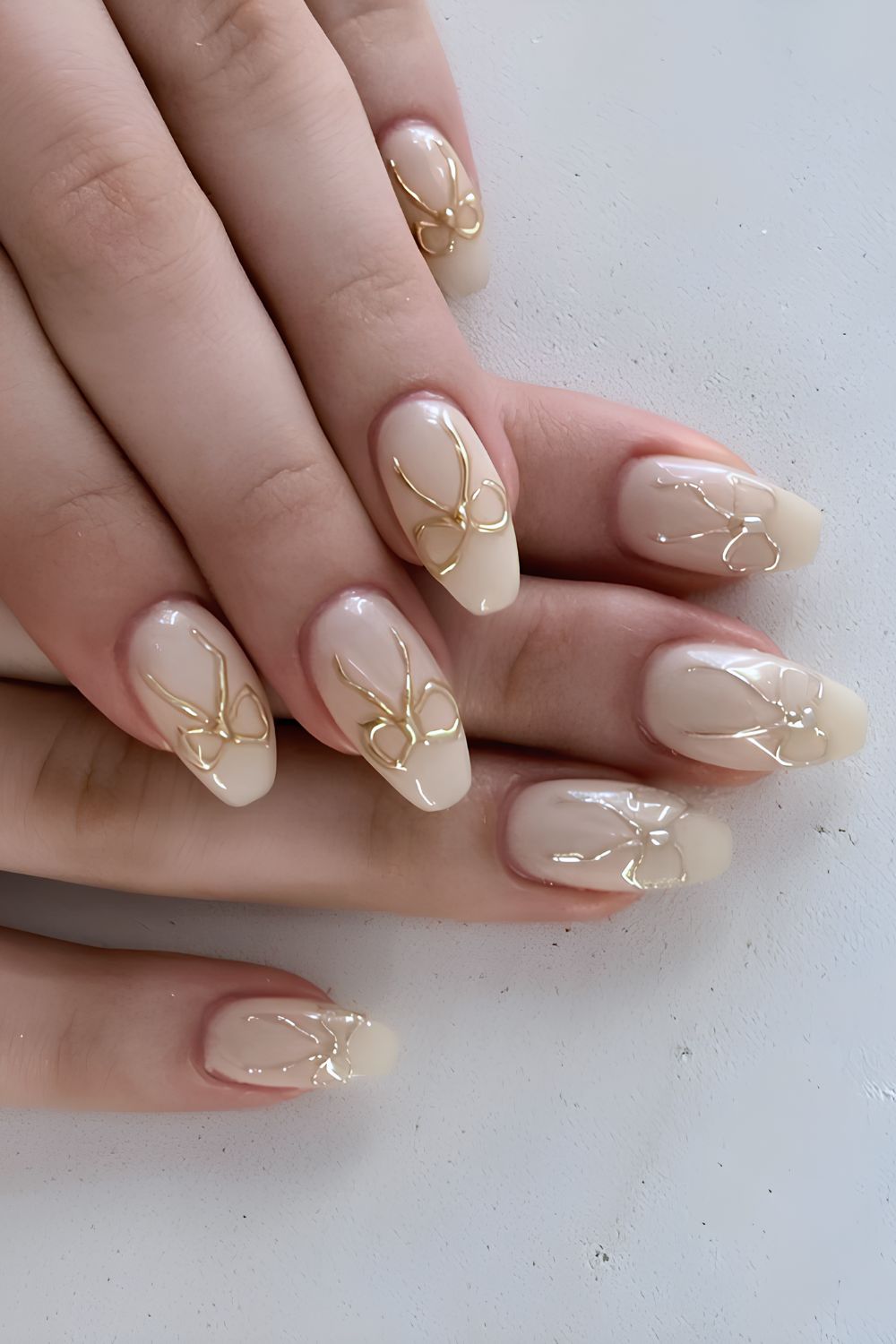 White nails with gold chrome bows