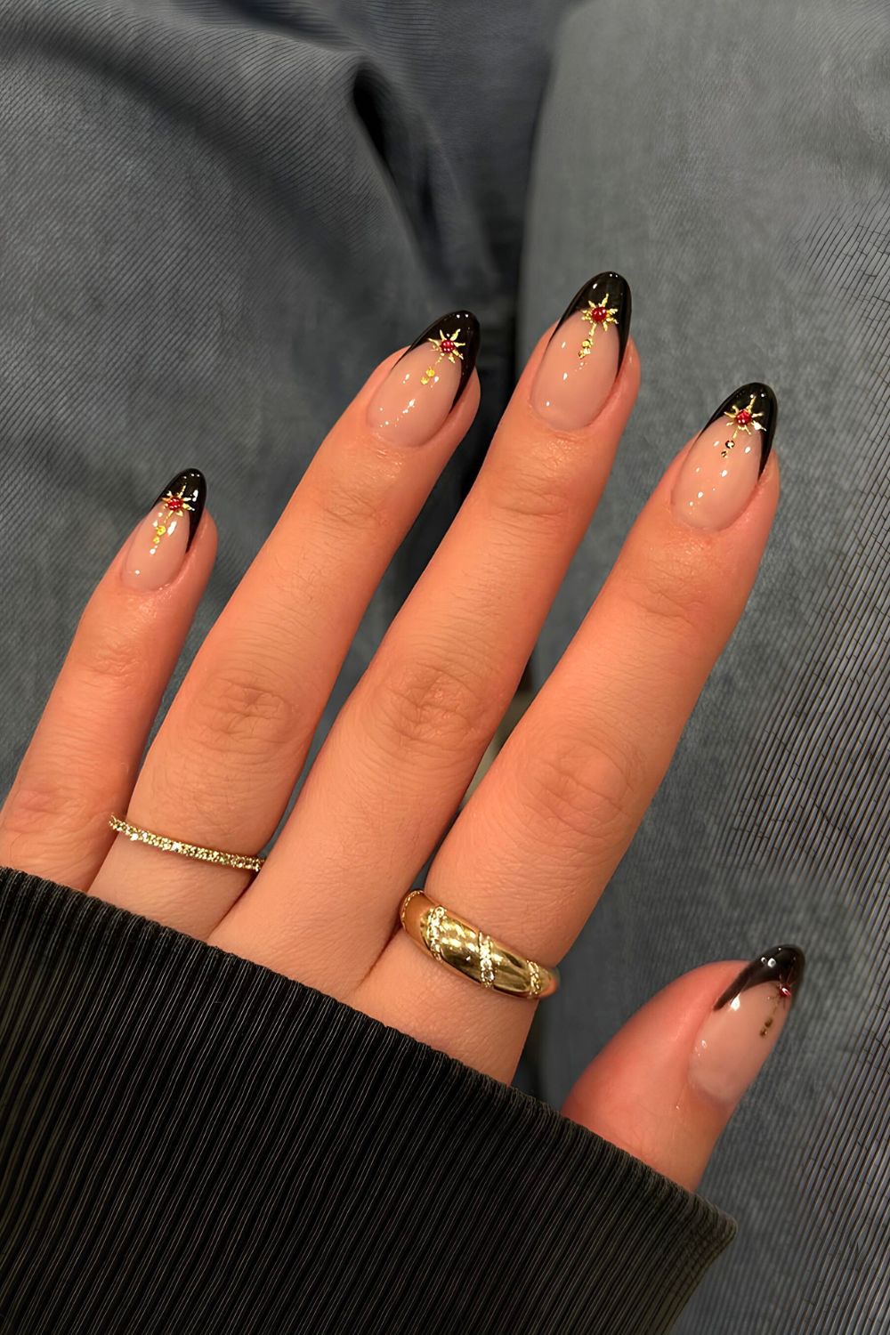 Black French tip nails with gold and red star accents