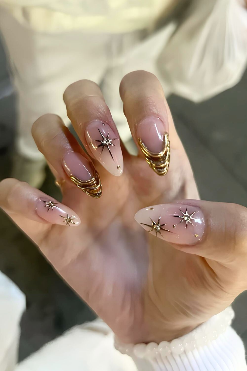 Gold chrome French tip nails with gold star accents