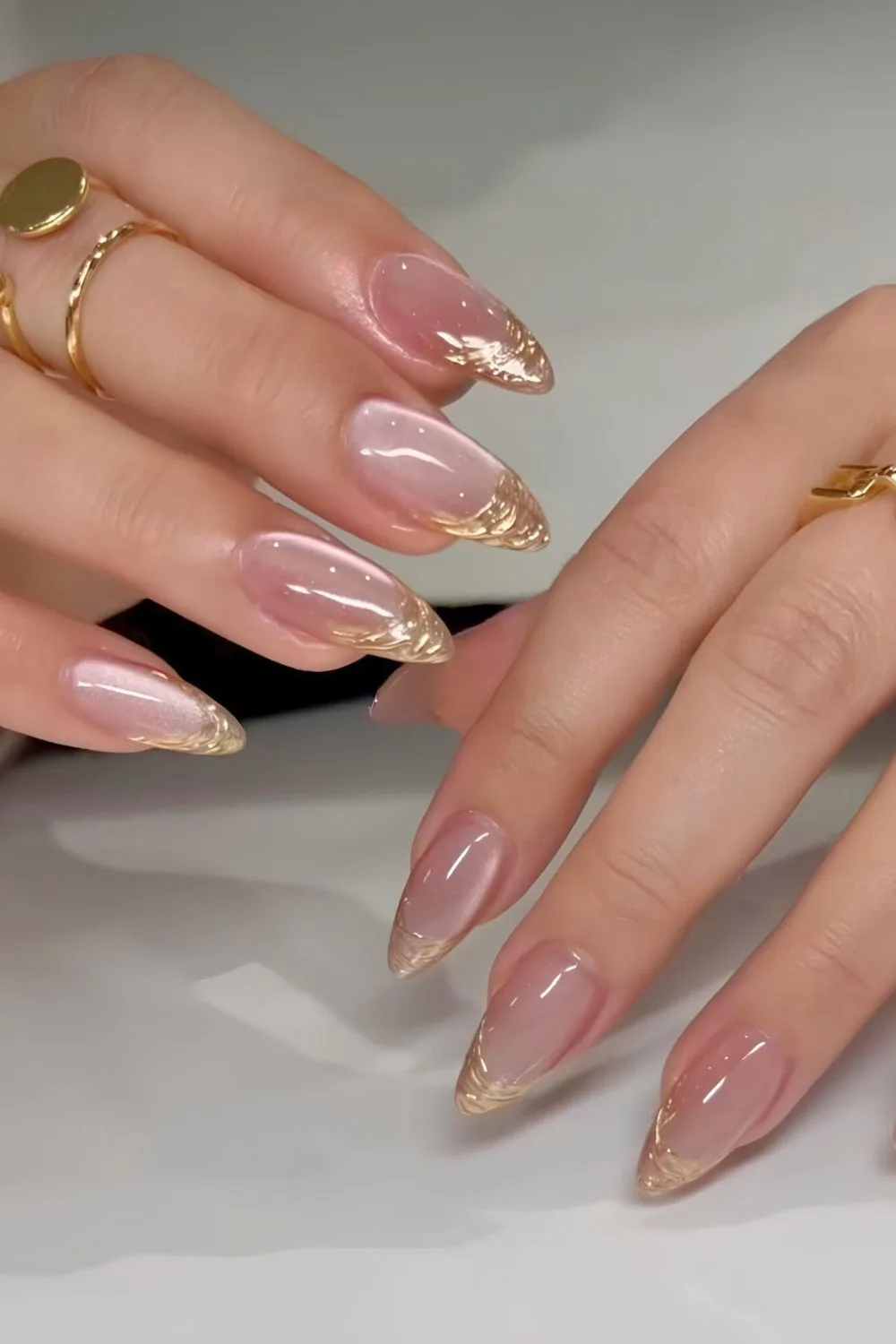 Gold chrome French tip nails with soft pink velvet base