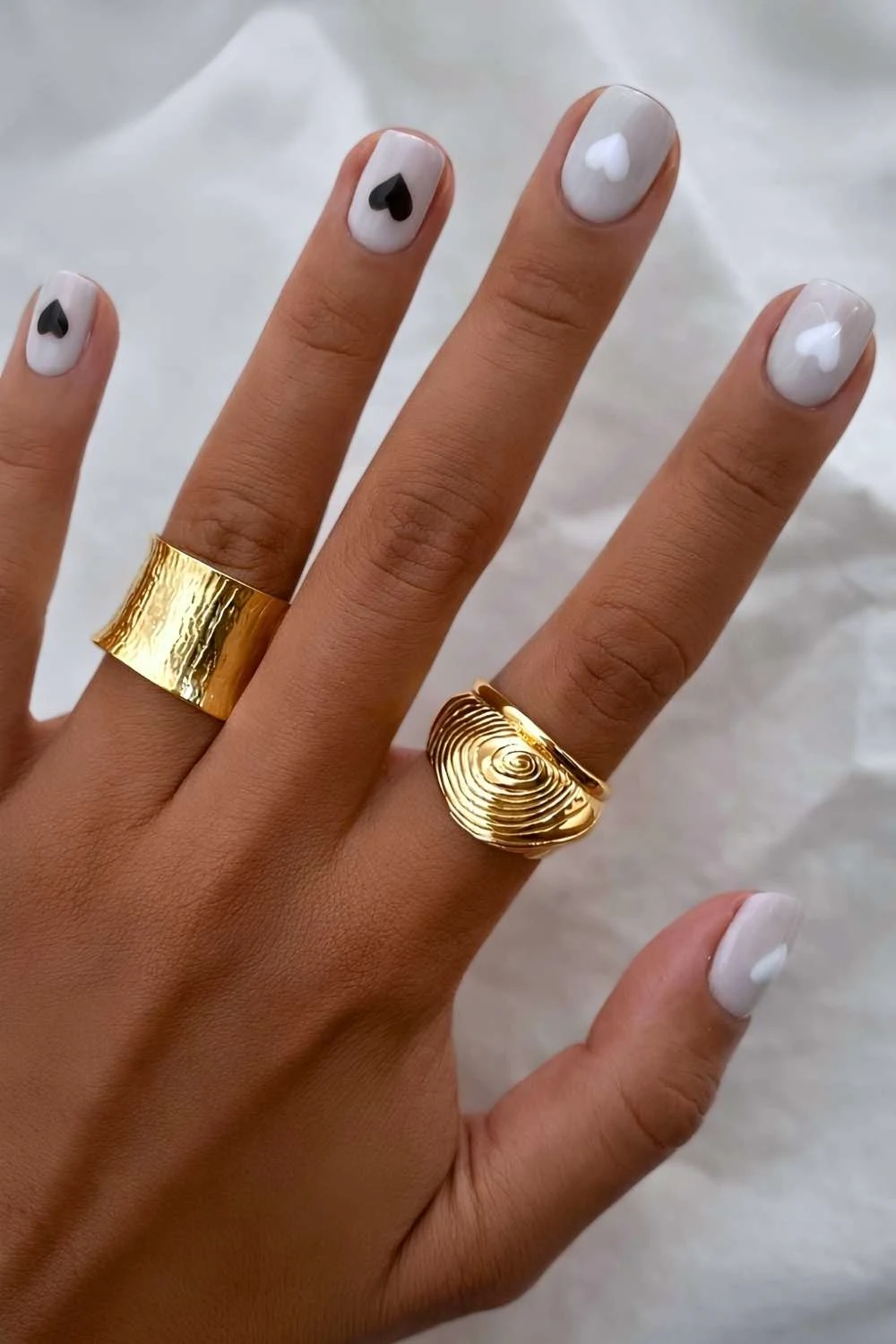 Gray nails with white and black hearts