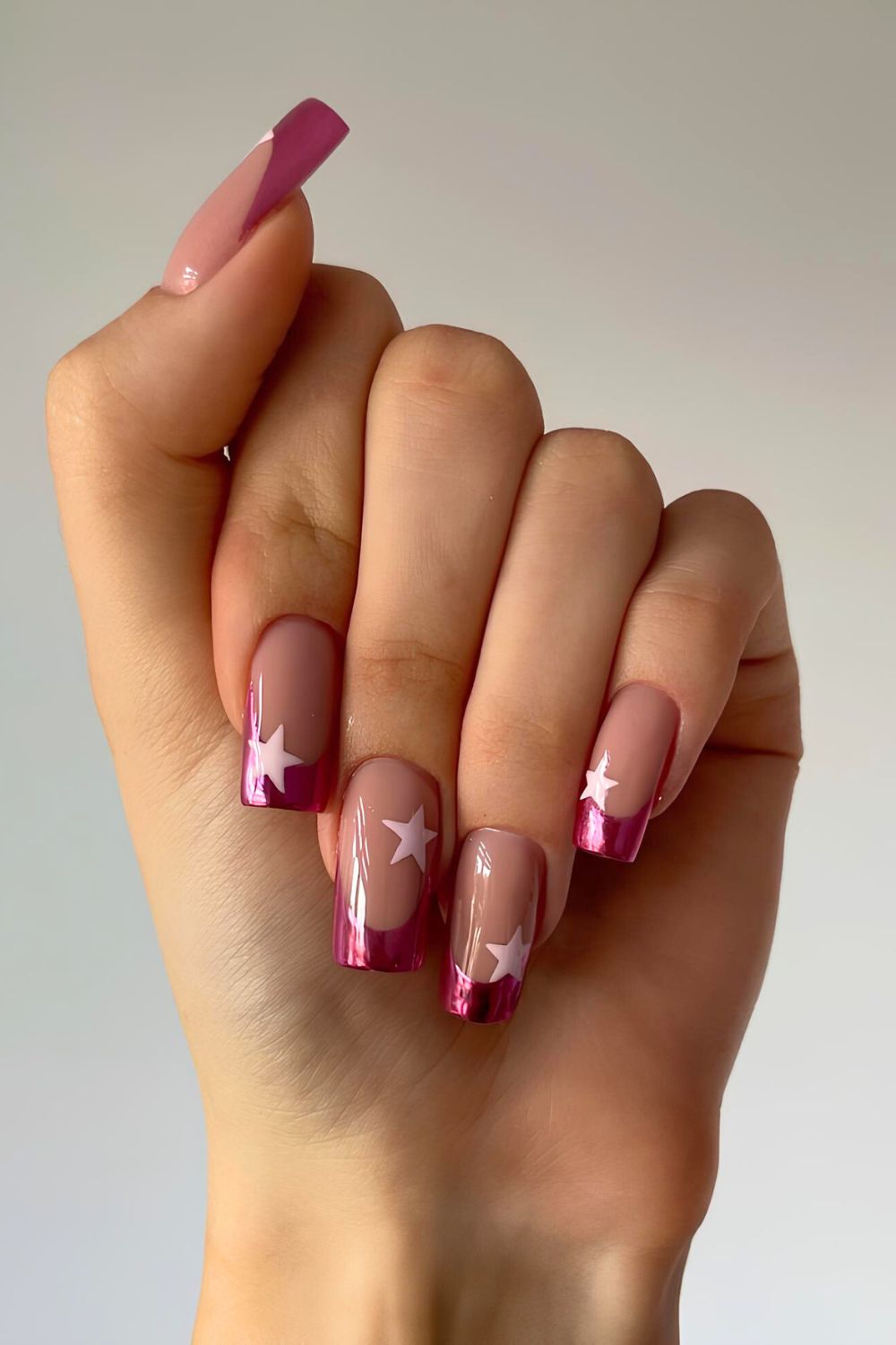 Hot pink chrome French tip nails with star accents