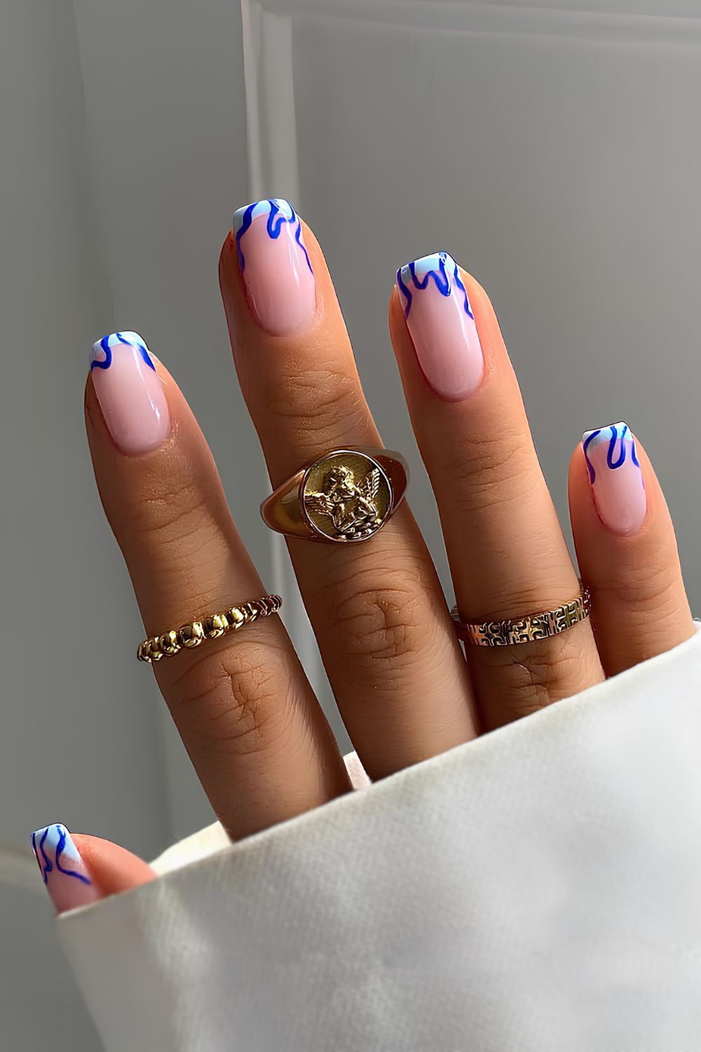 Light blue French nails with navy swirls