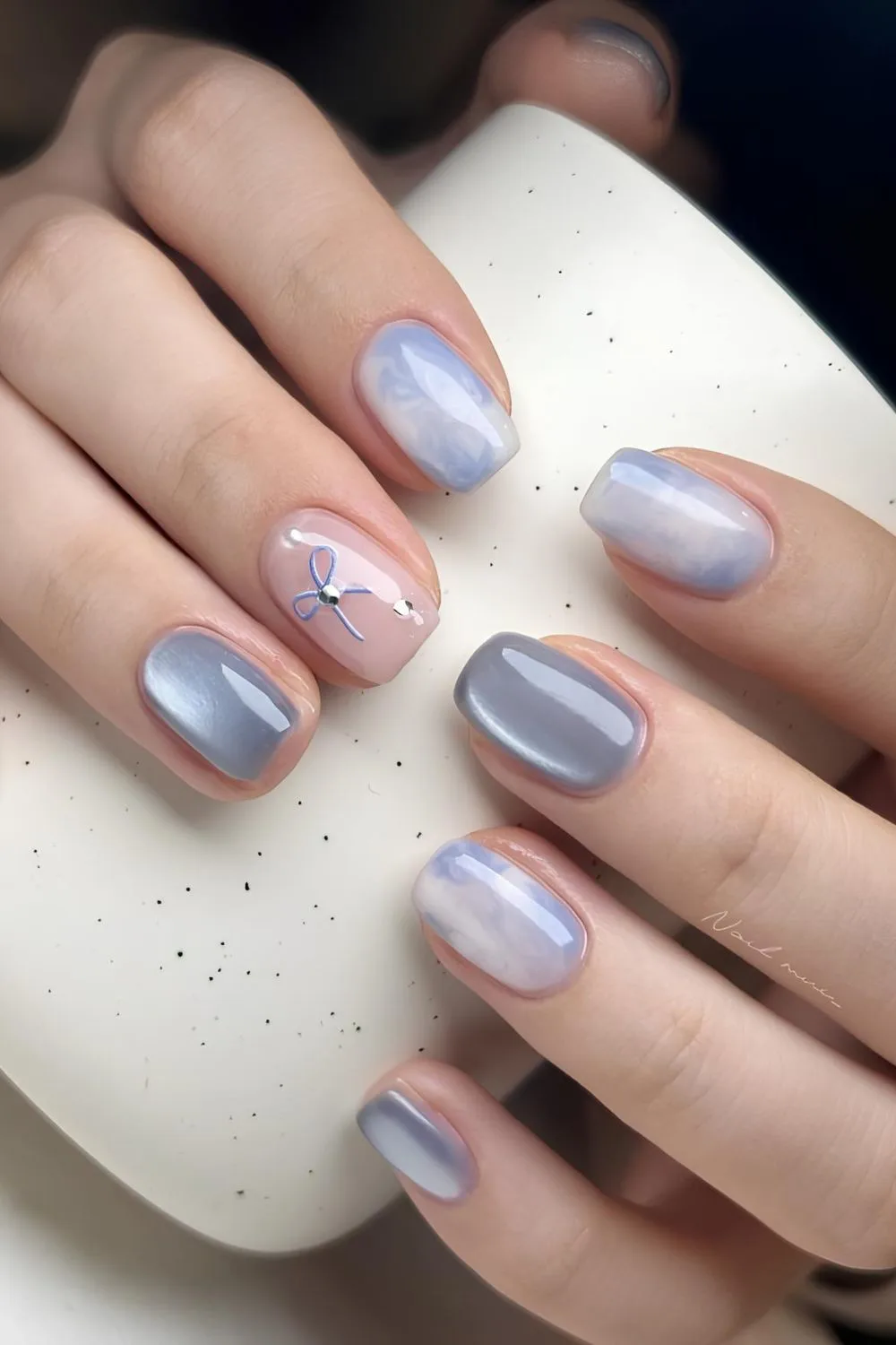 Light blue marble nails with glass effect and a bow