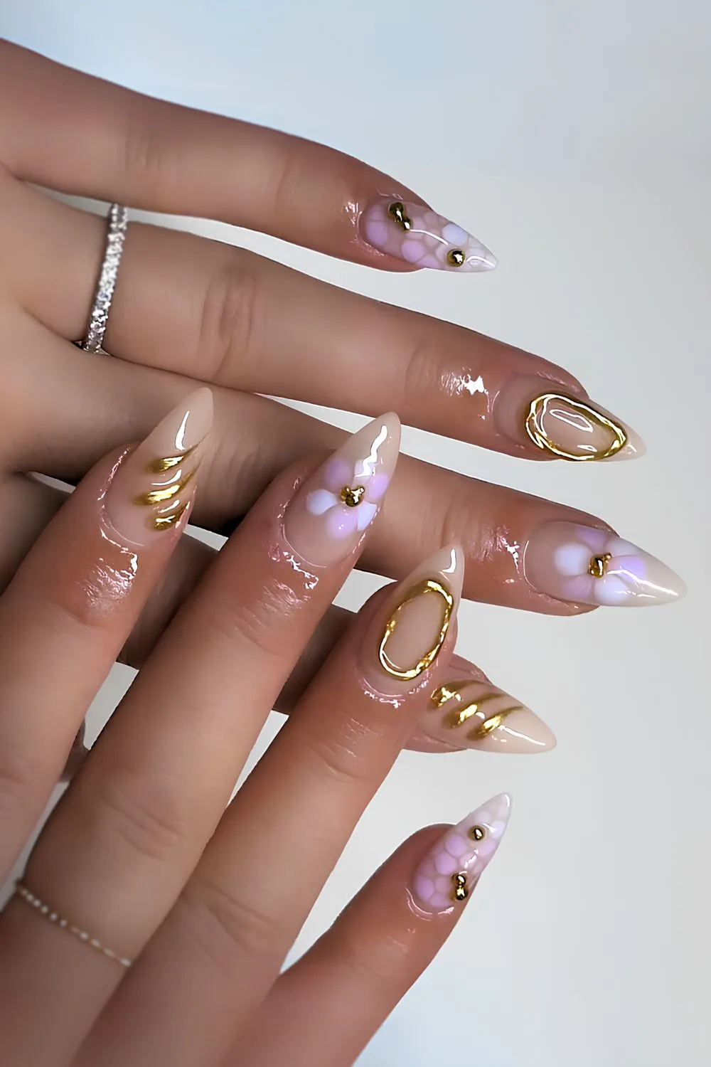 Milky nails with purple blooms and gold chrome accents