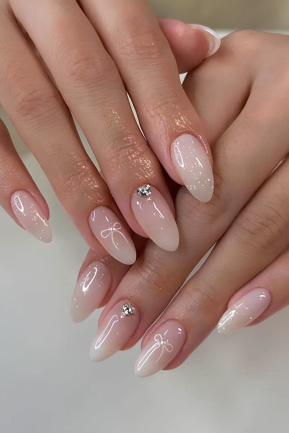 Milky ombre nails with gems and bows