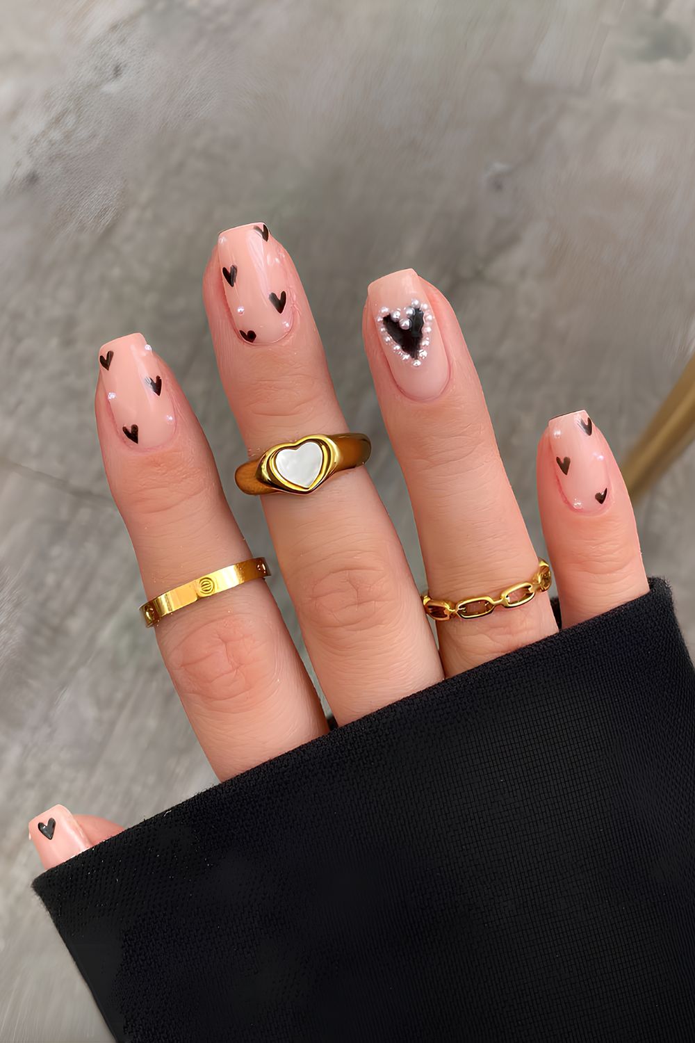 Neutral mani with pearls and black hearts