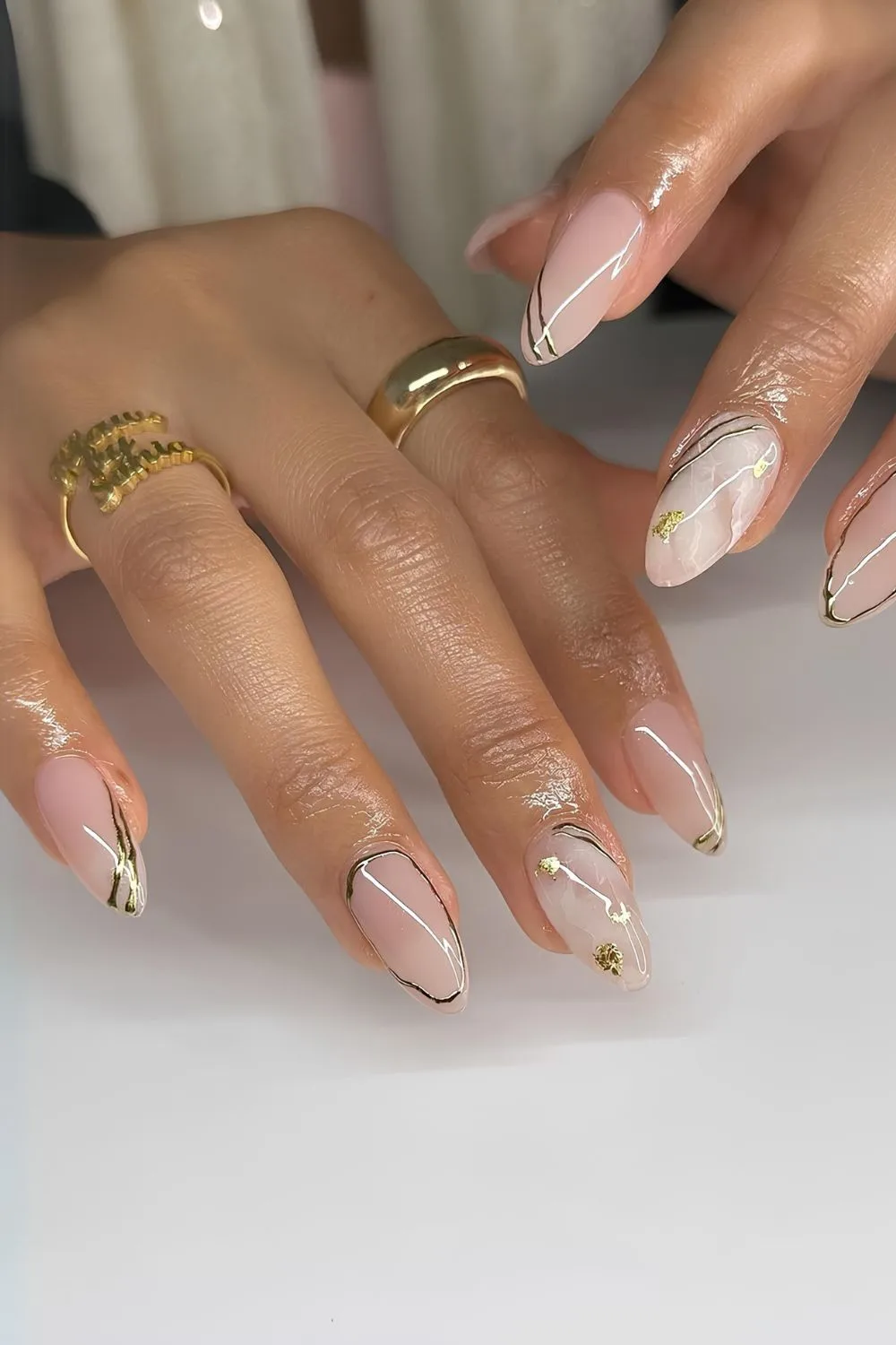 Neutral marble nails with silver chrome accents and gold foil