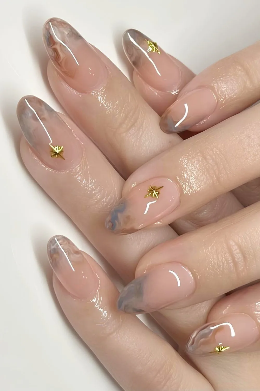 Neutral marble tip nails with gold star accents