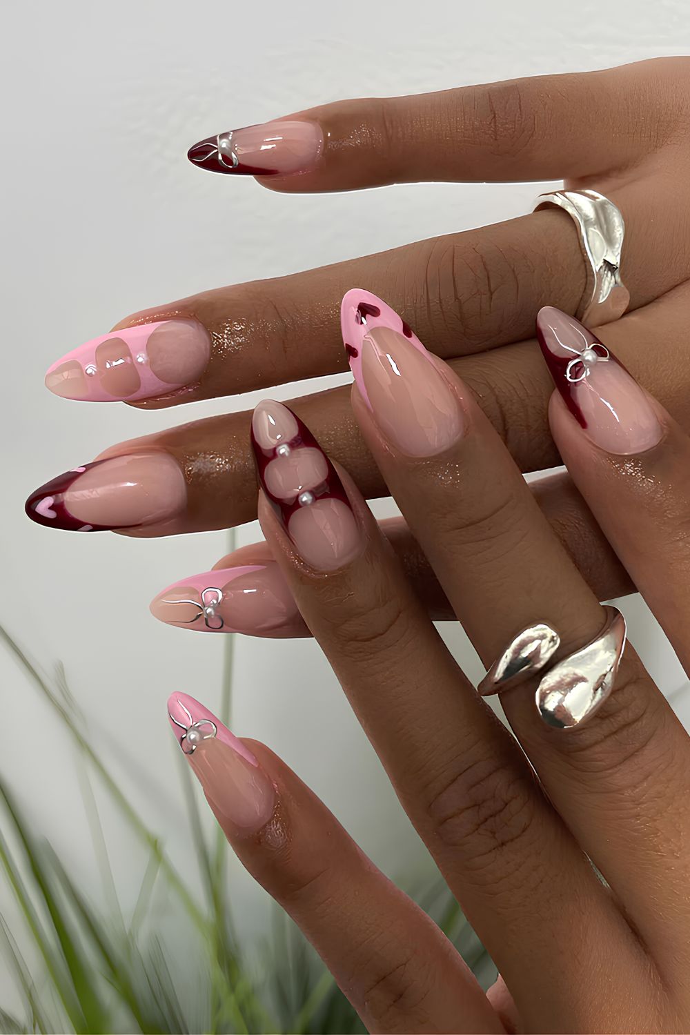 Pink and dark red nails with bows and hearts