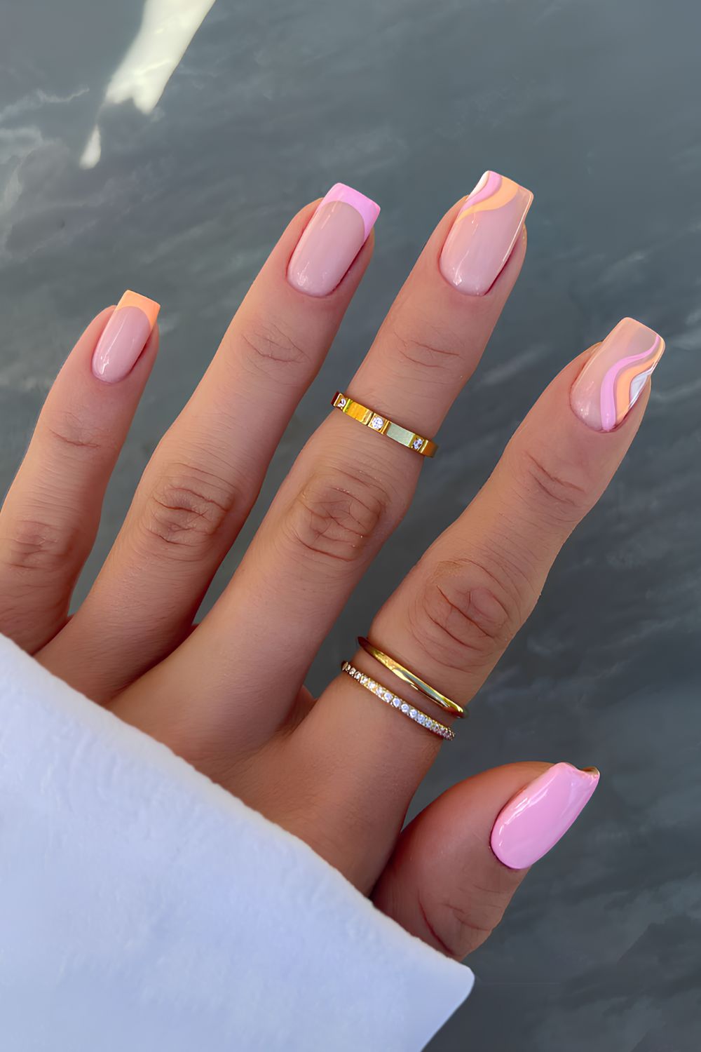 Pink and orange nails with swirl details