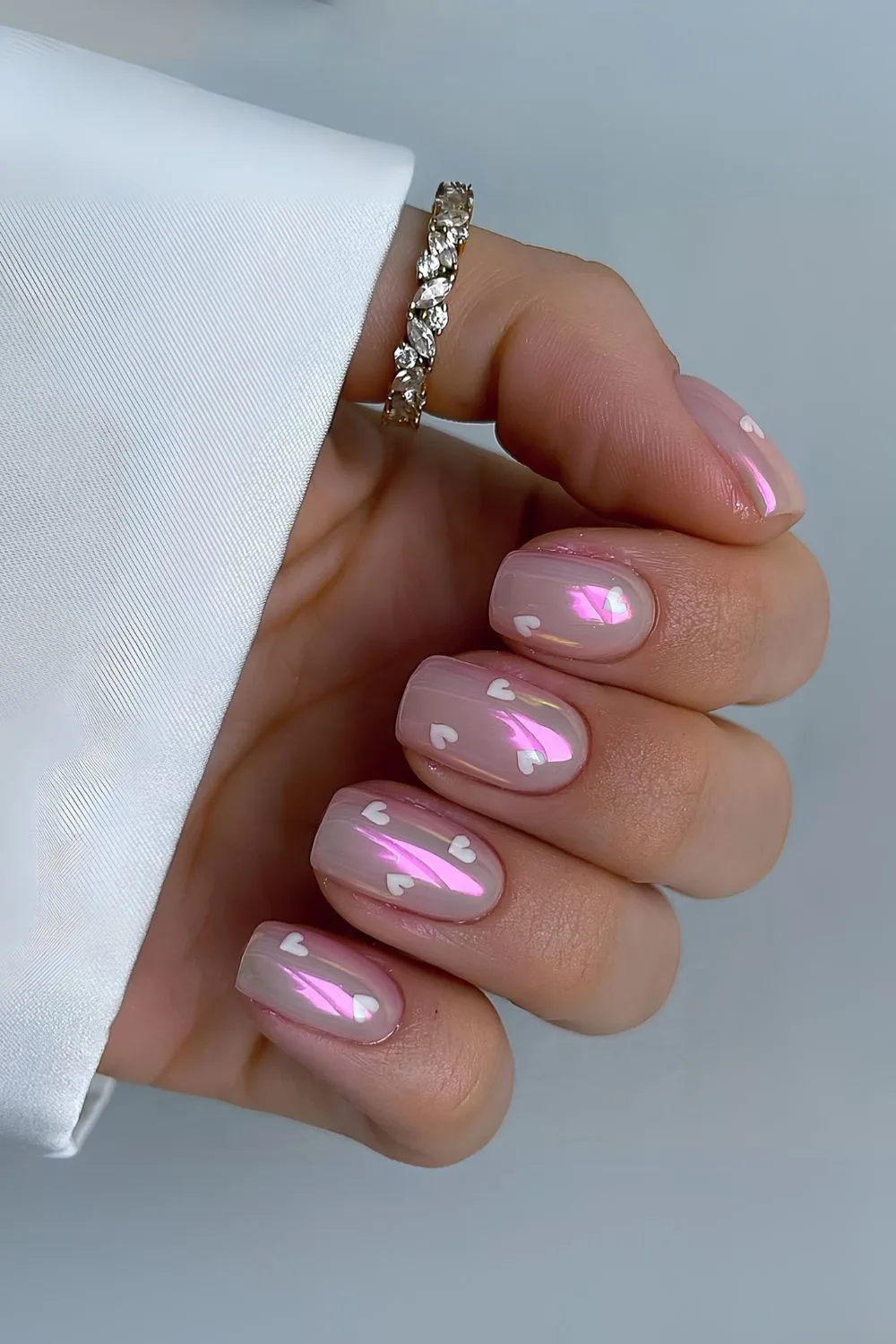 Pink chrome nails with white hearts