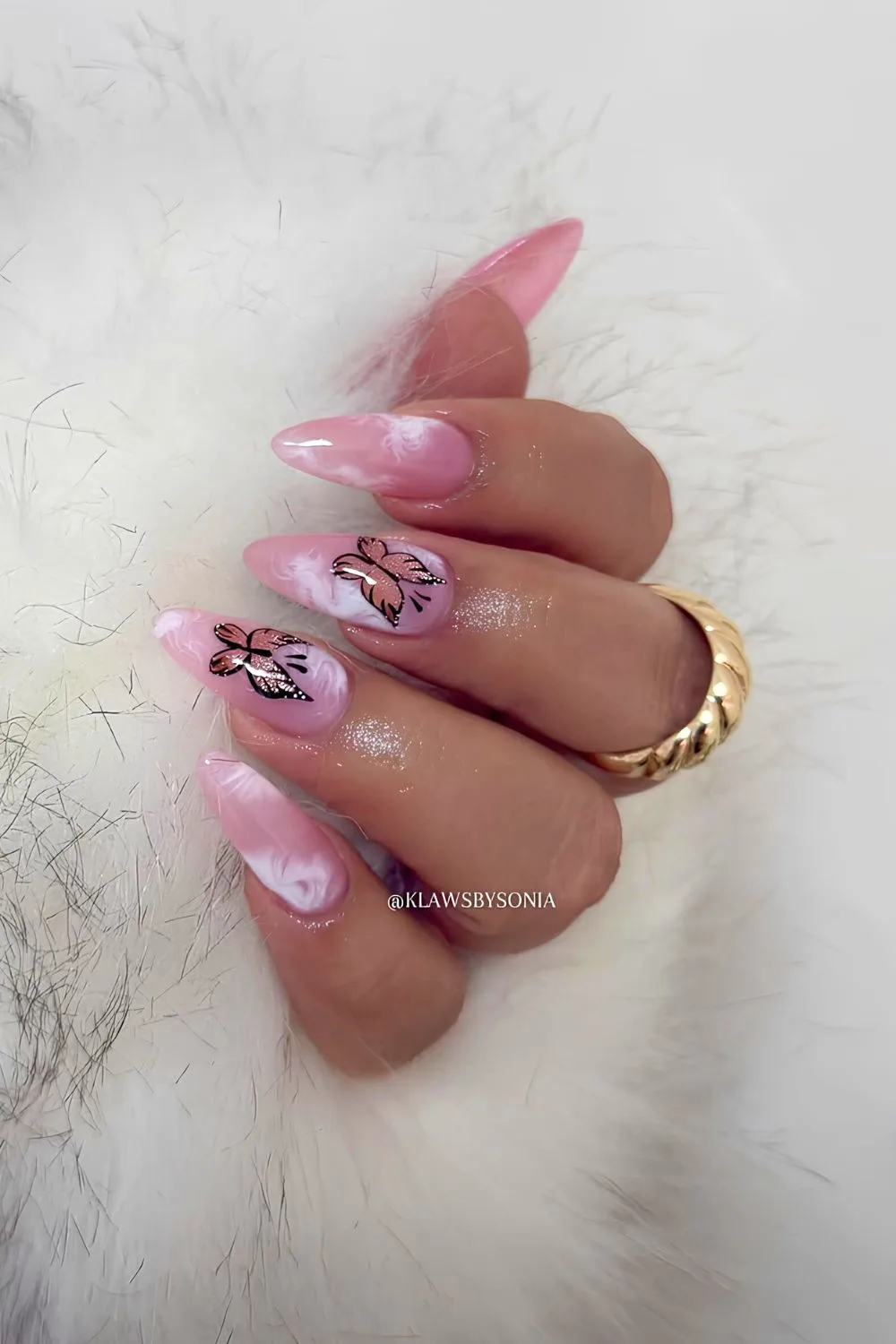 Pink marble nails with butterfly accents