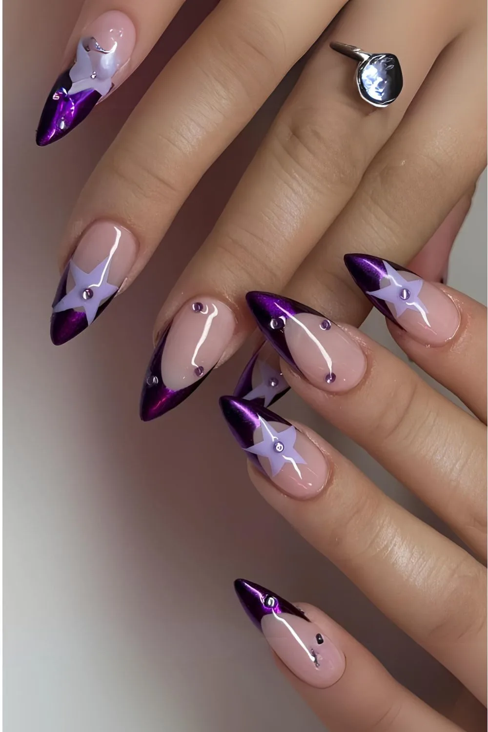 Purple chrome French tip nails with light purple stars and rhinestones