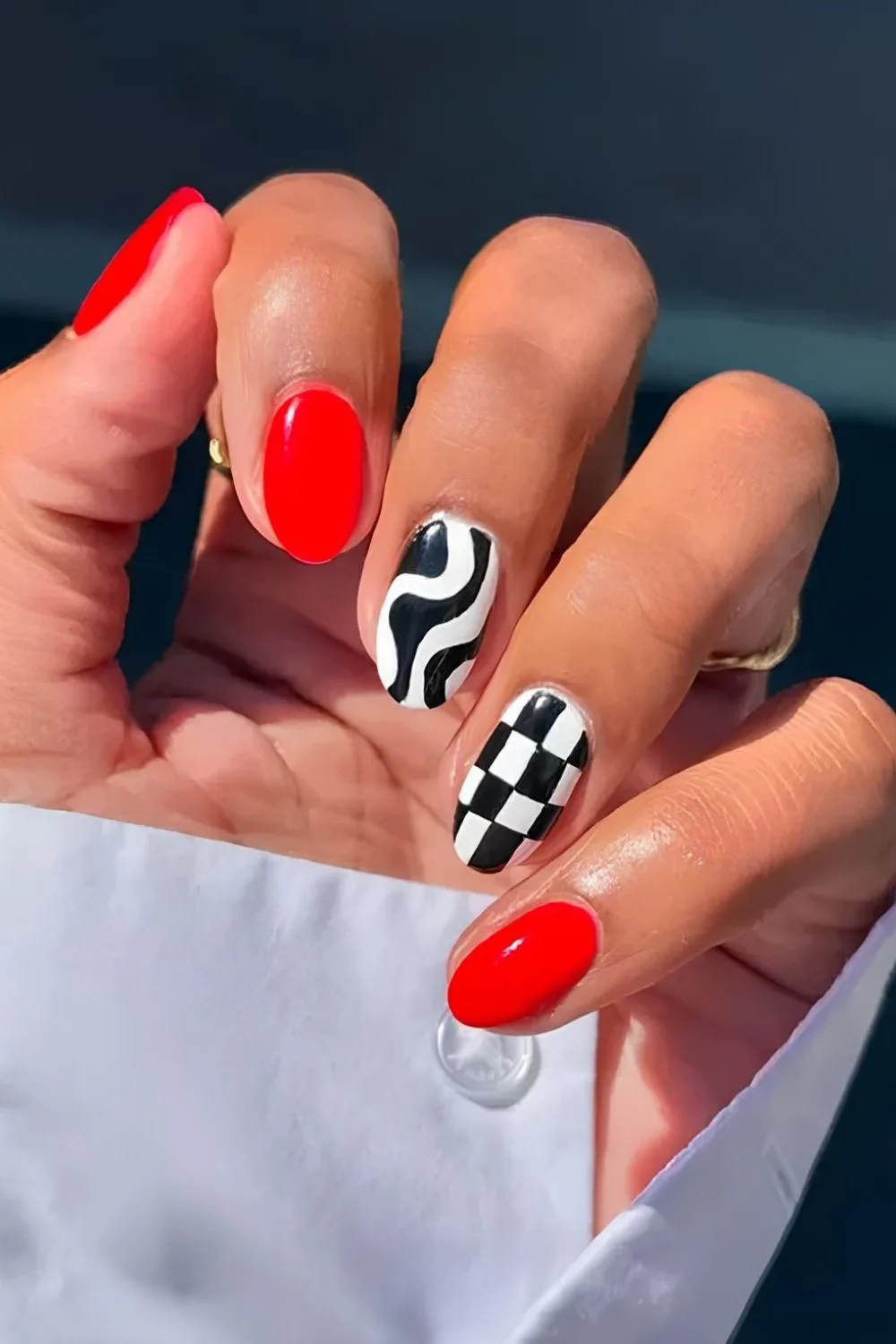 Red and black nails with checkerboard and swirls