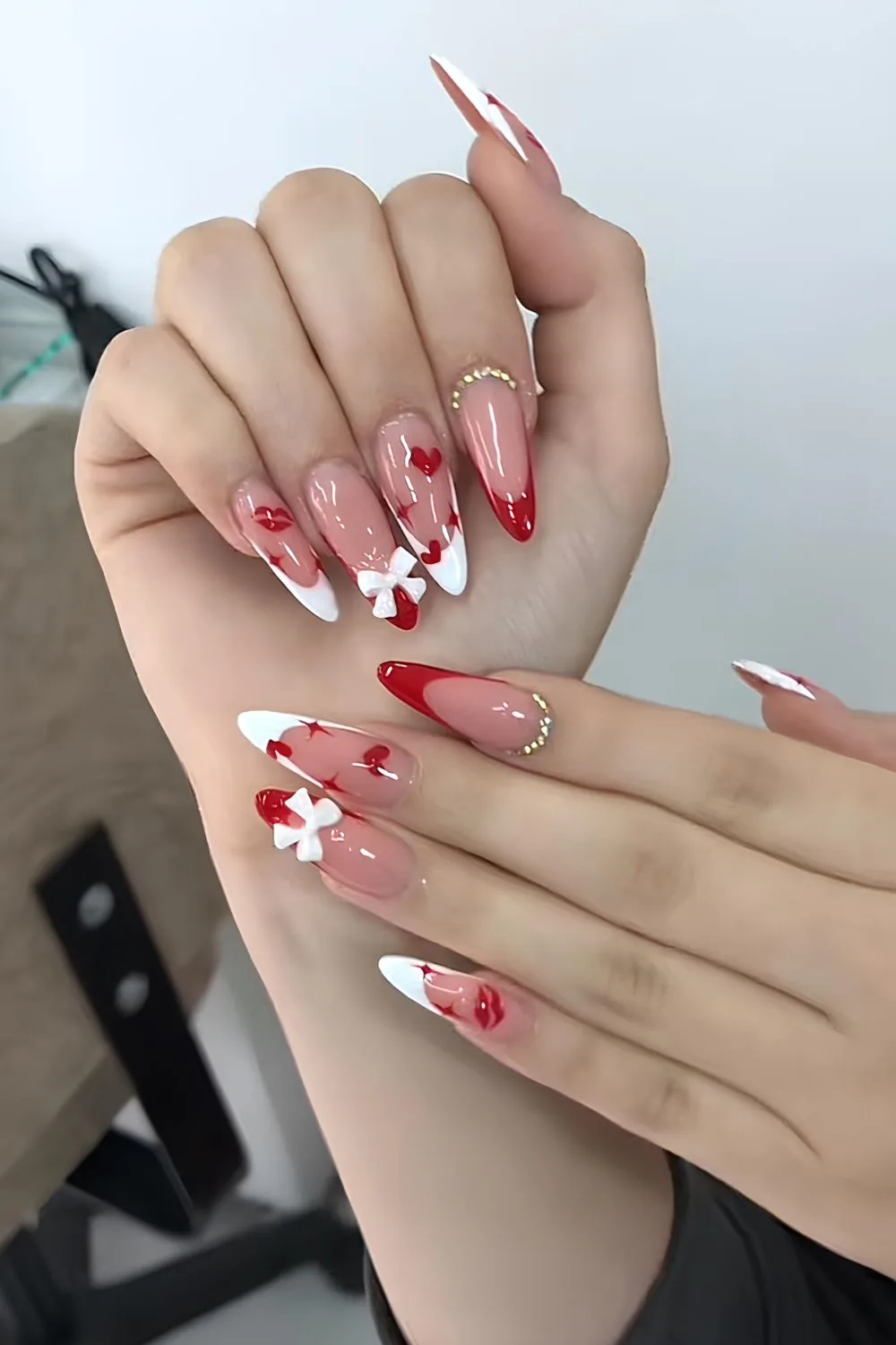 Red and white French tips with 3D bows and tiny kiss accents