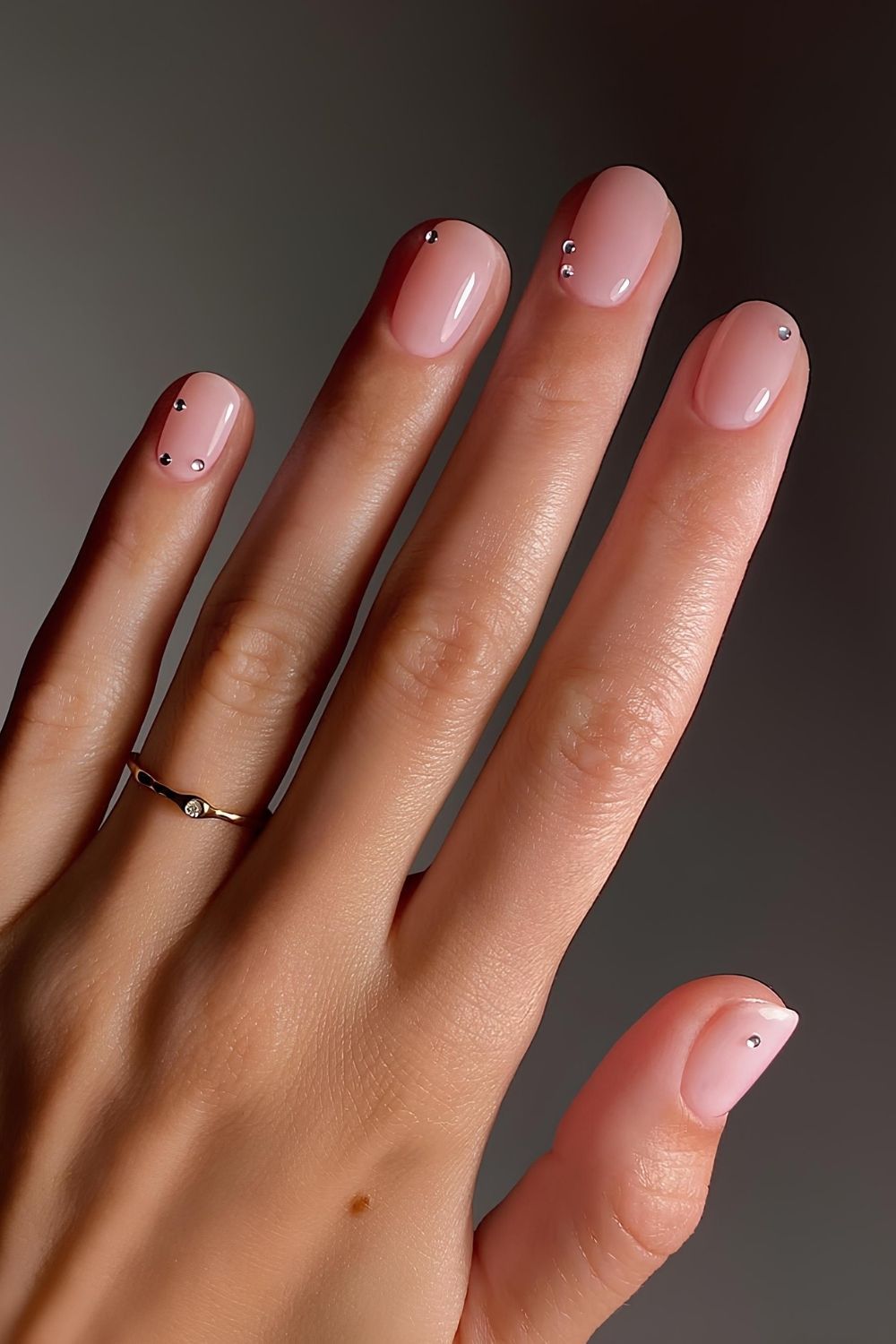 Sheer pink nails with subtle gem accents