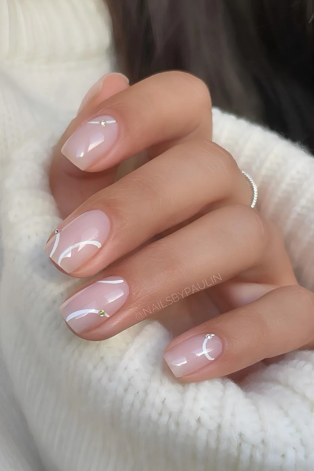 Sheer white nails with swirls and gems