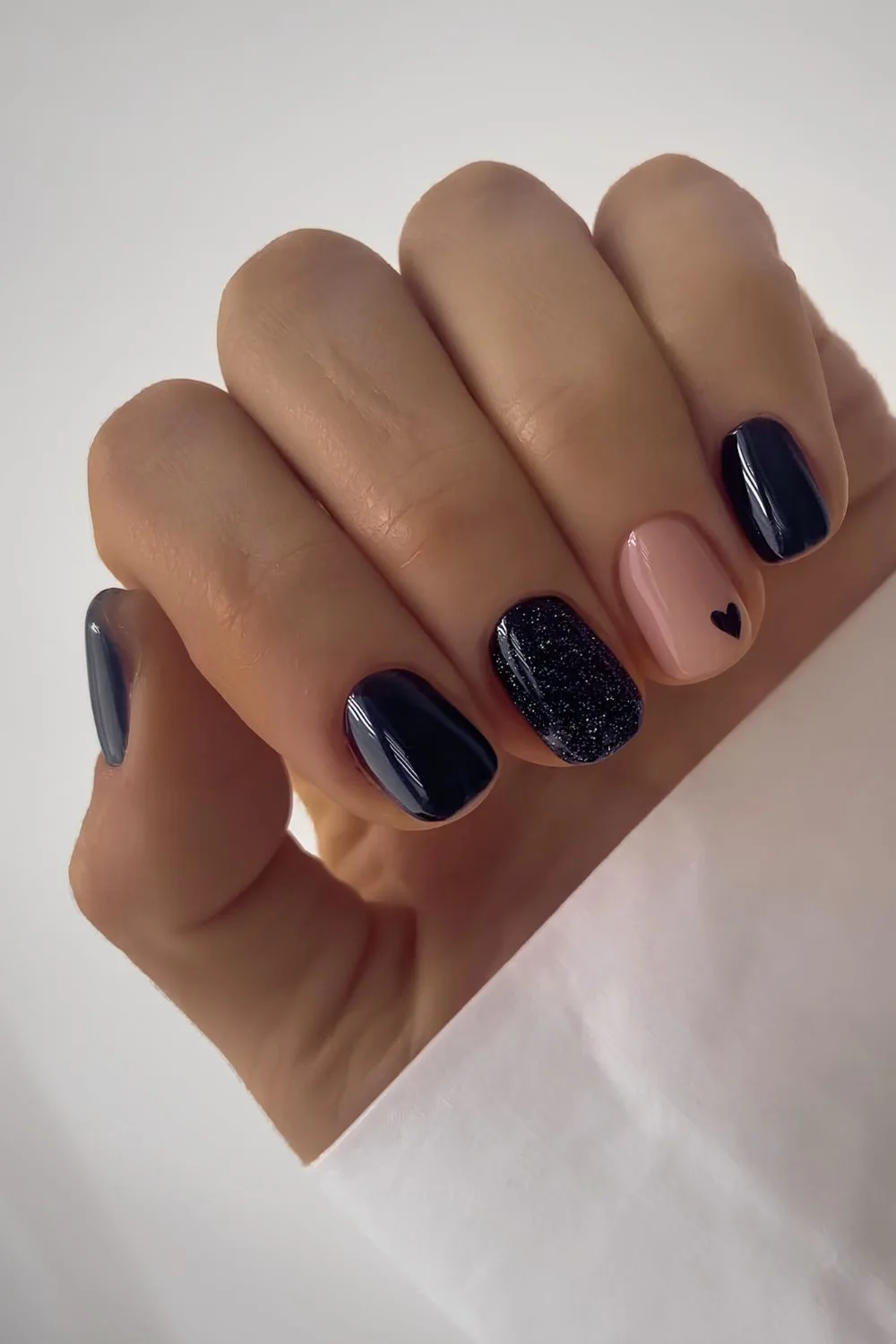 Short black nails with hearts and glitter