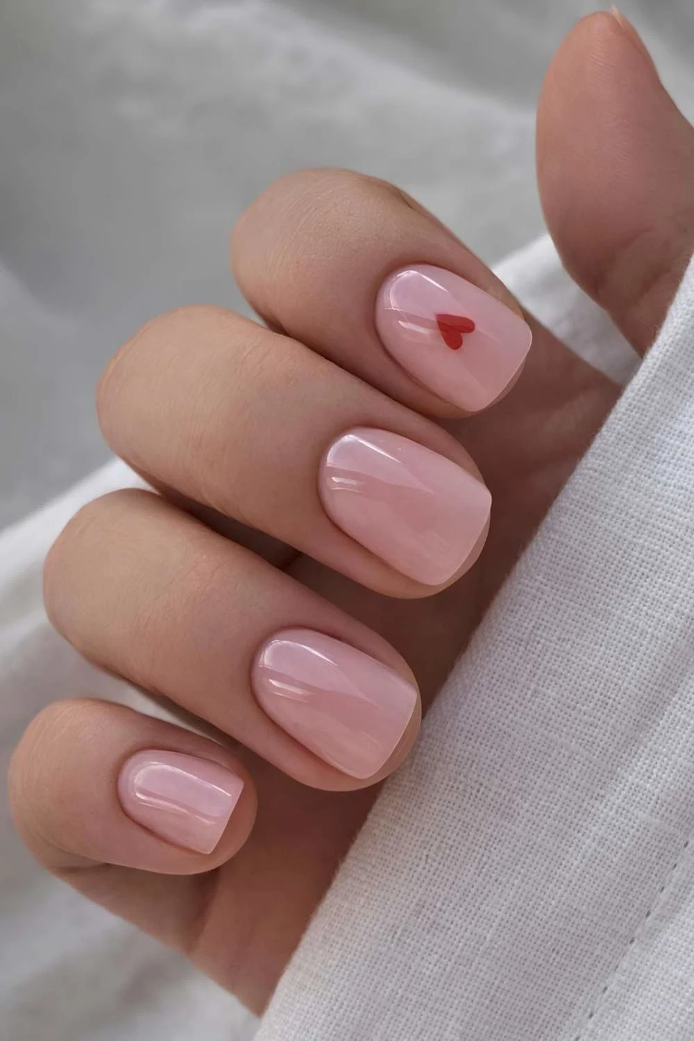 Short pink mani with minimalist heart art