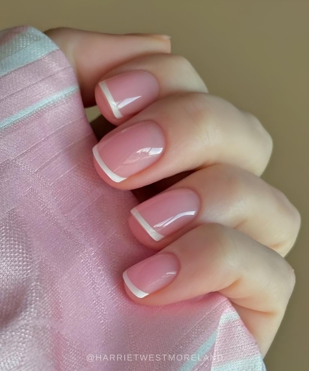 Short white French mani on glowy pink base