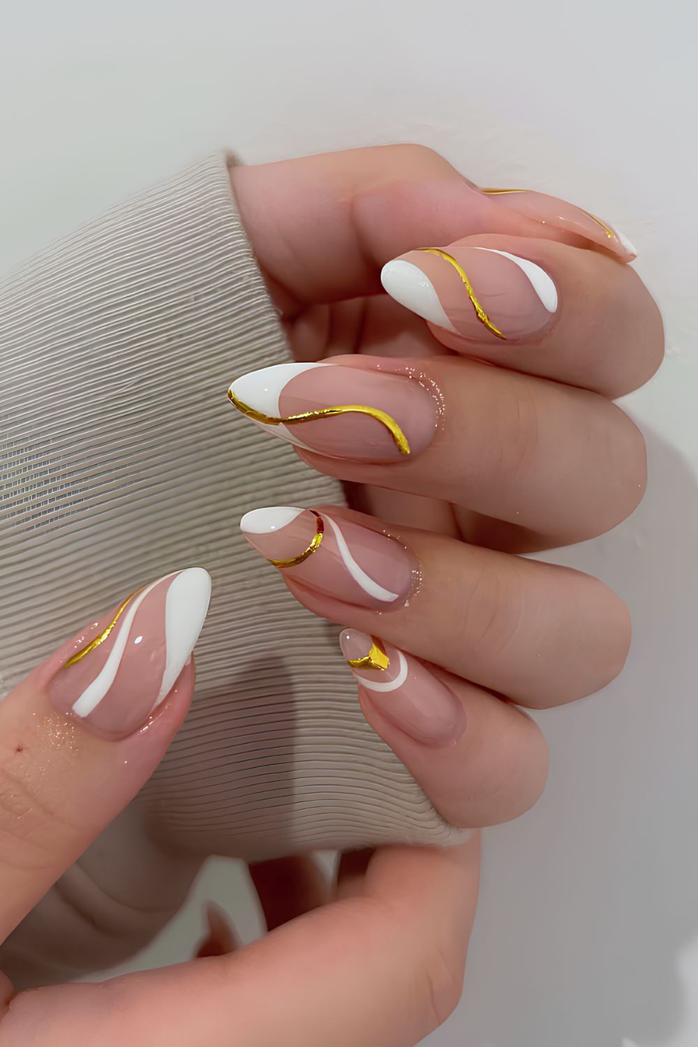 White French manicure with gold swirls