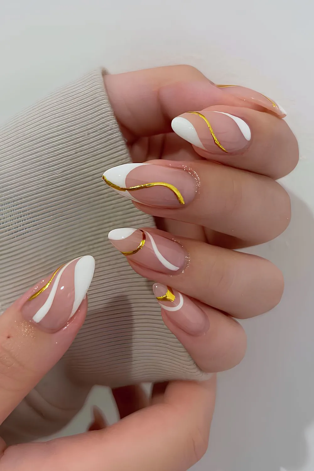 White French manicure with gold swirls