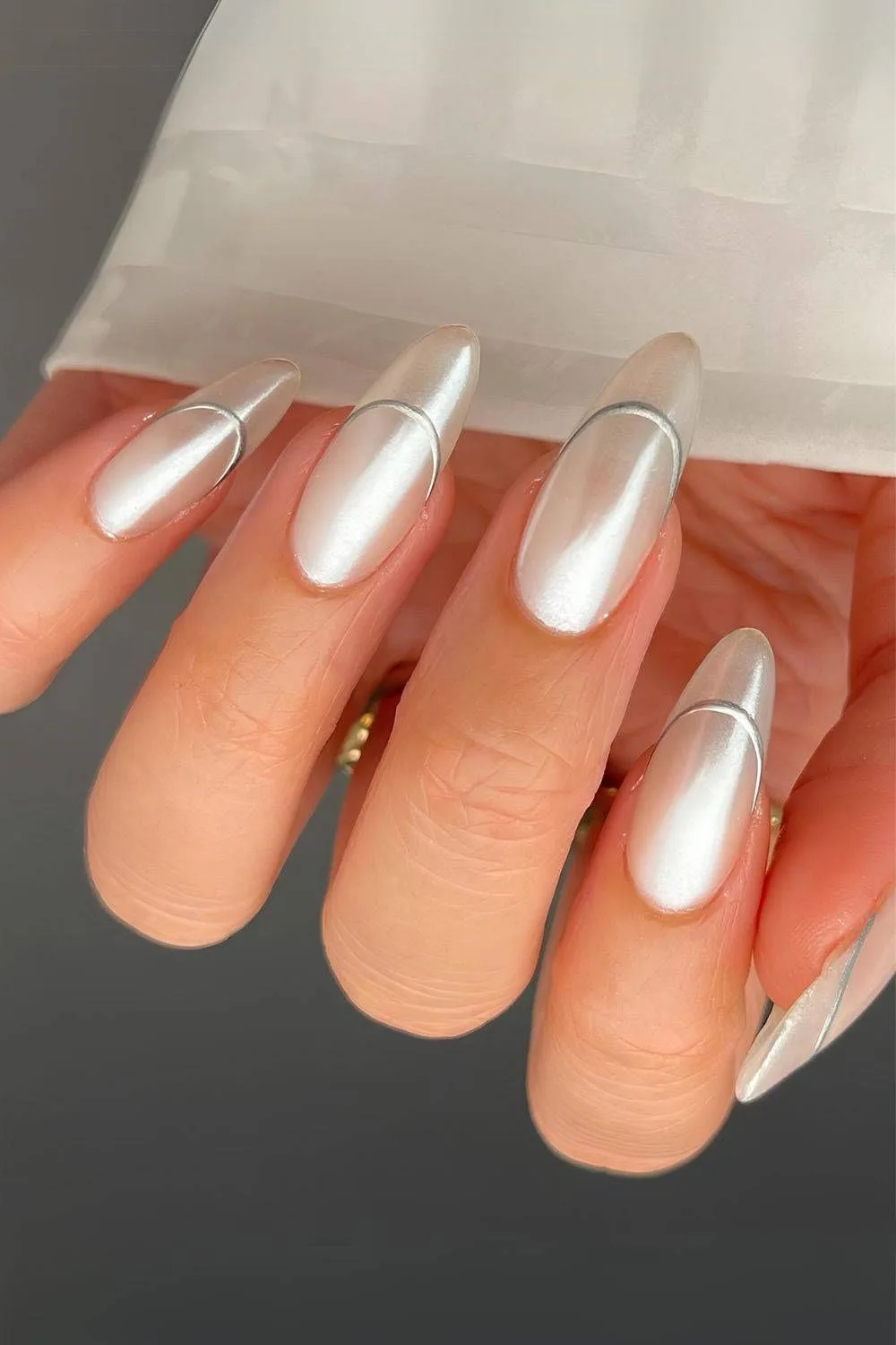 White chrome French tip nails with silver outline and pearl finish