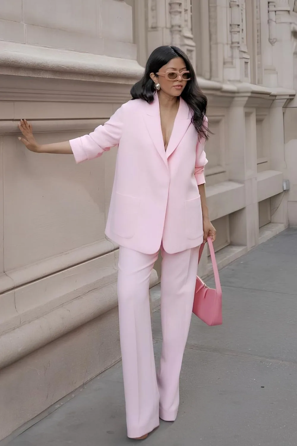 Woman posing in powder pink suit and pink bag