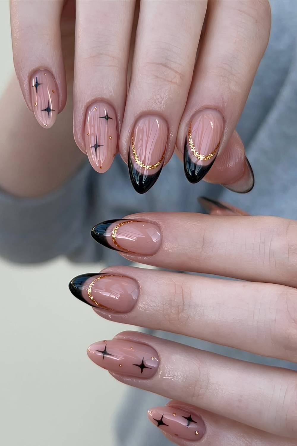 Black French nails with gold glitter lines and stars