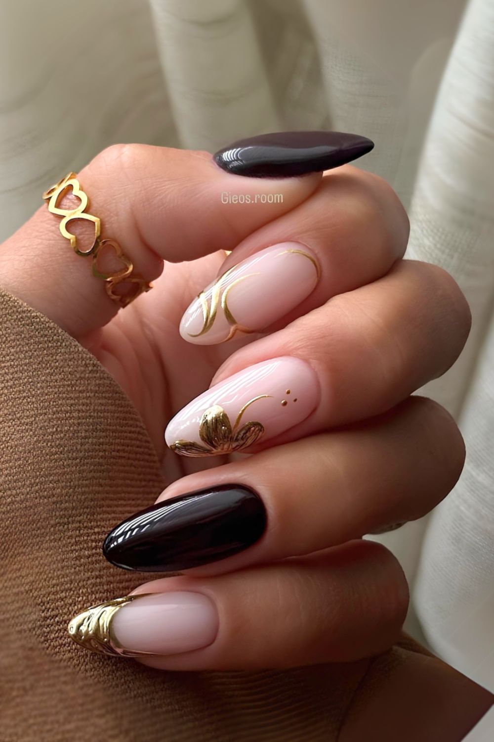 Black nails with gold chrome florals and swirls