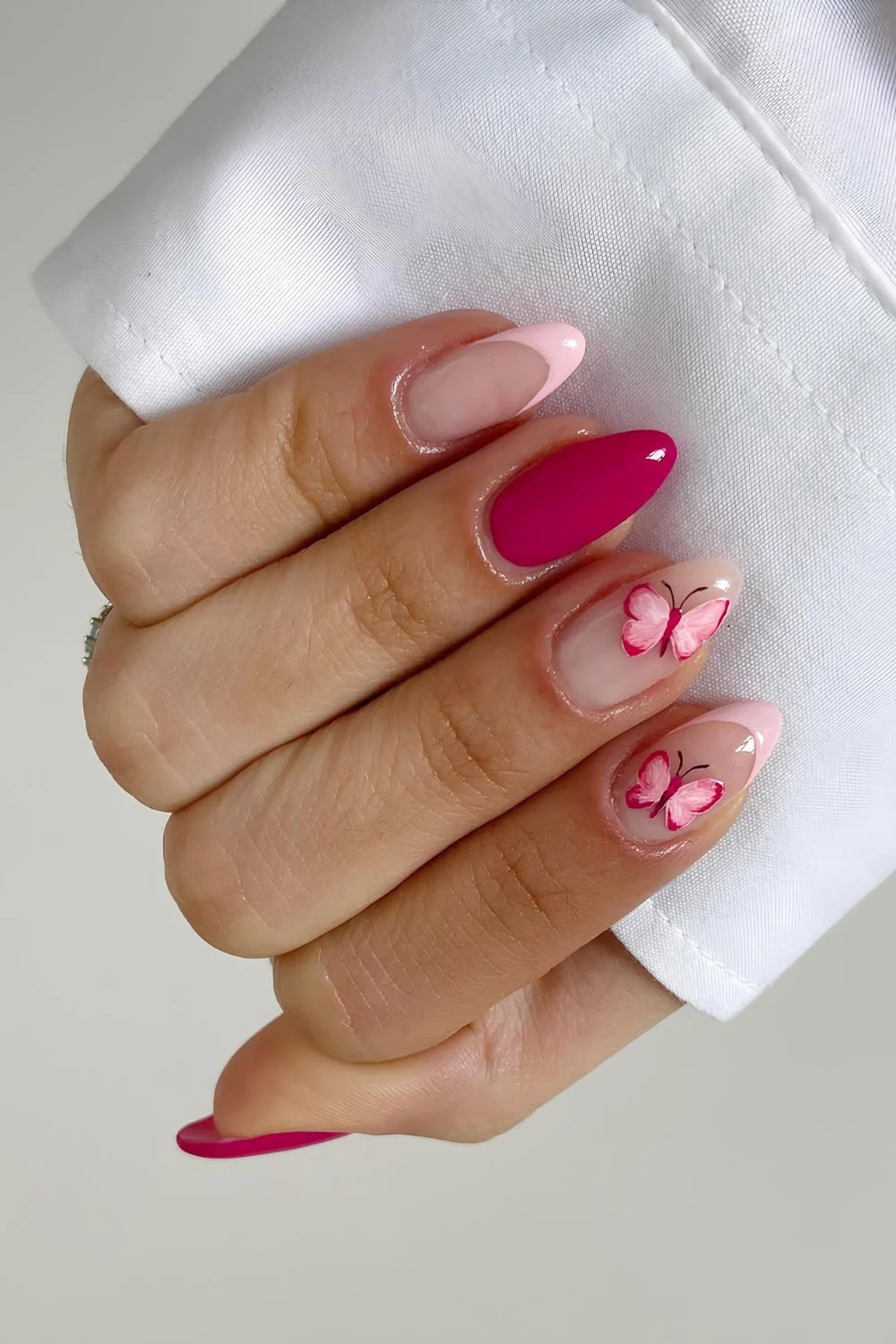 Pink nails with butterfly accents