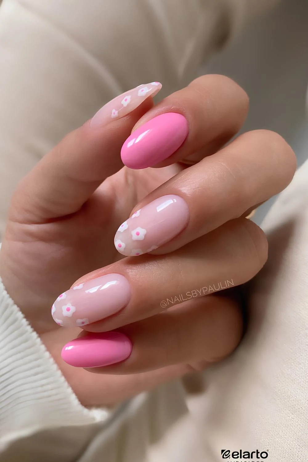 Pink nails with floral tip accents.