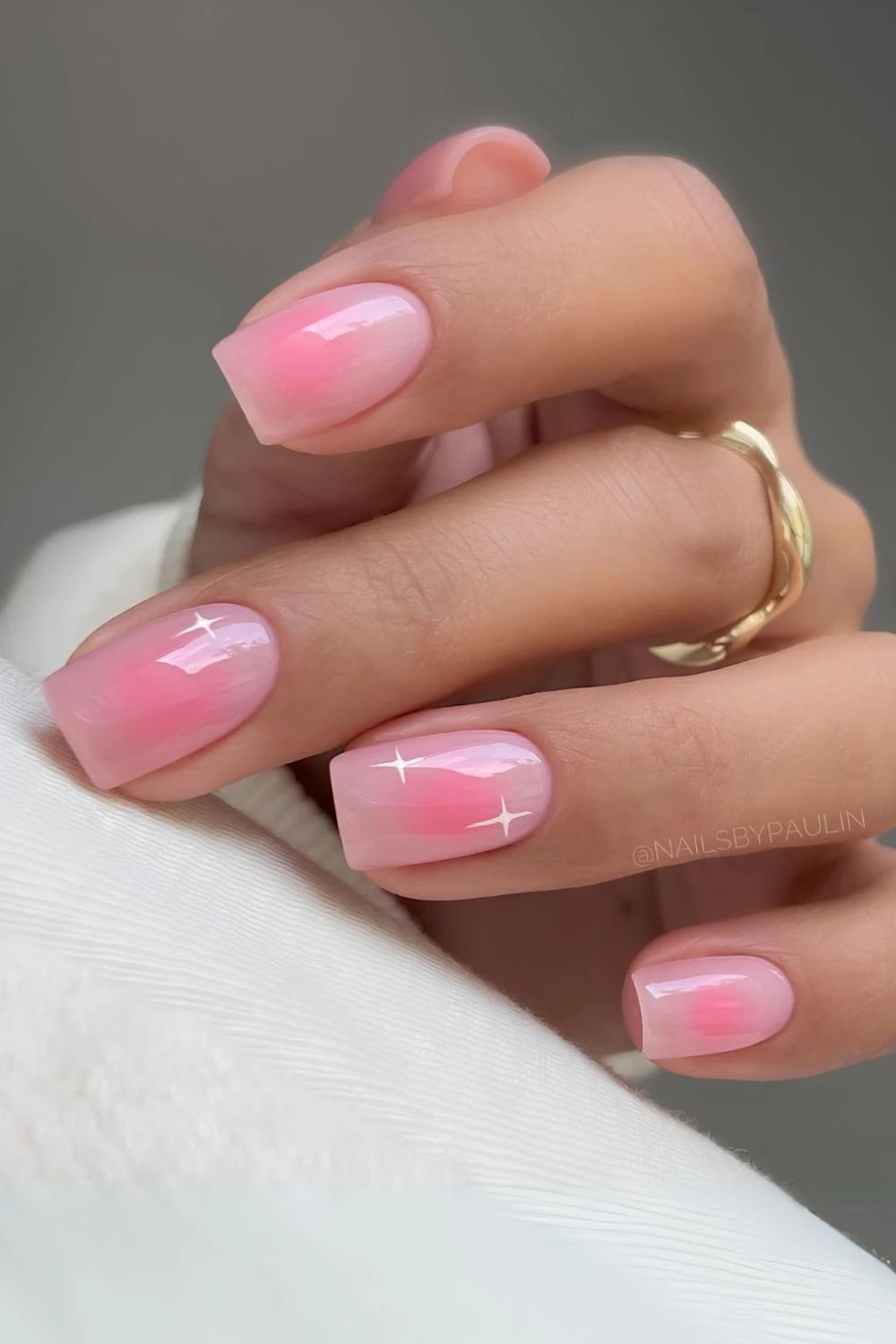 Soft pink aura nails with tiny white stars