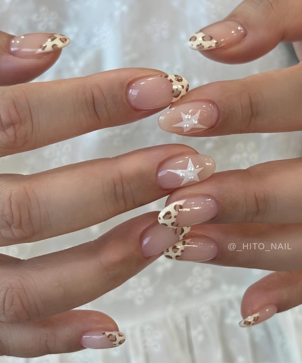 Vanilla French nails with leopard spots and stars