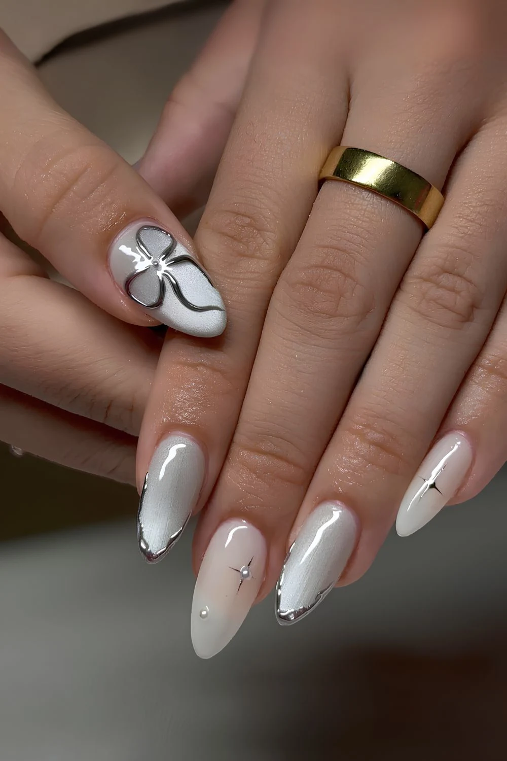 White cat eye nails with chrome bows and stars