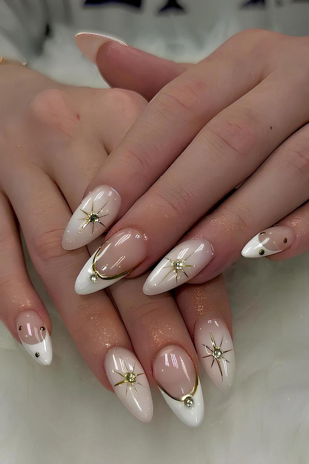 White nails with gold lines and stars