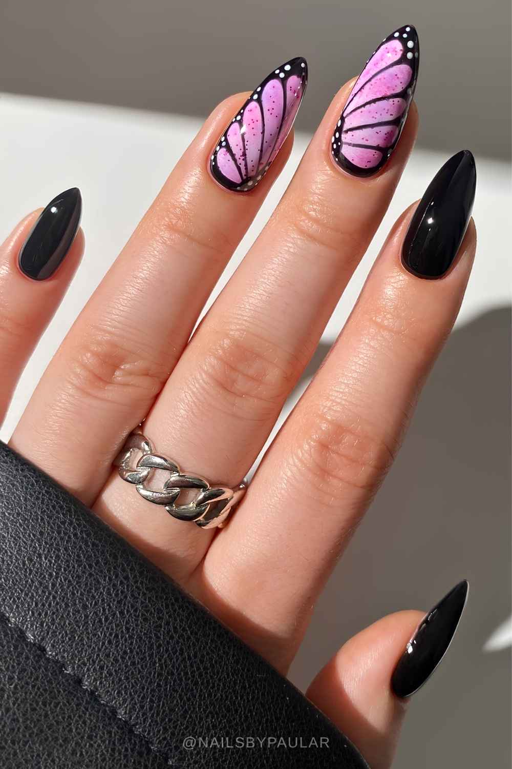 Black and pink nails with butterfly wing art