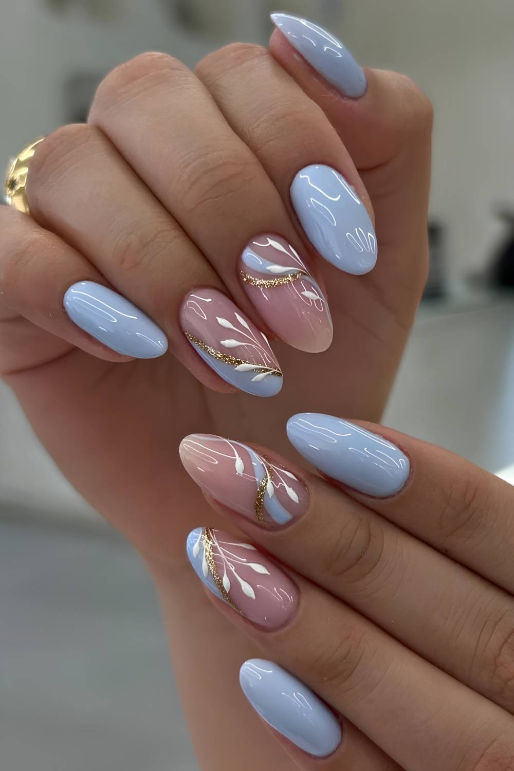 Blue nails with gold glitter and leaf art