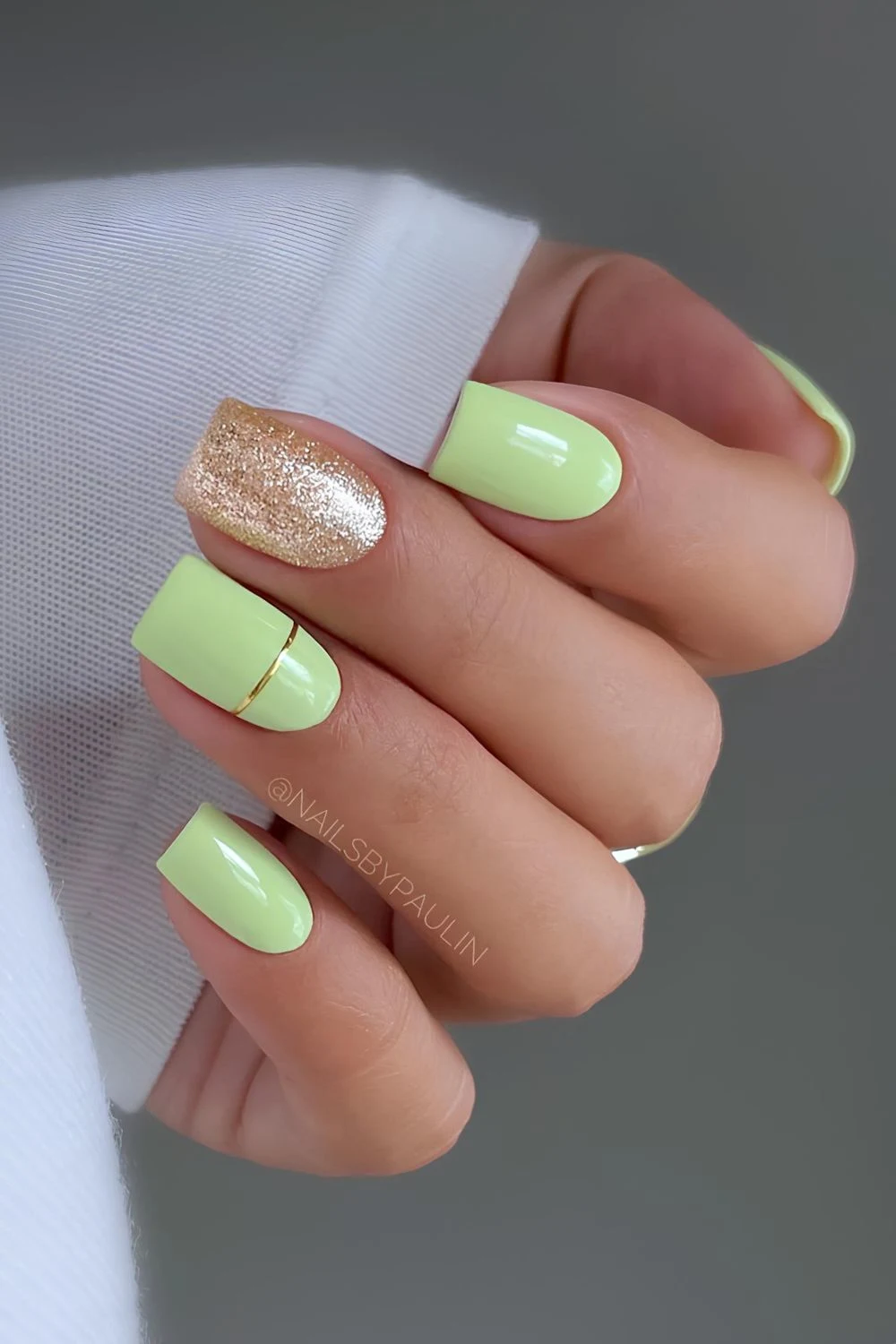 Light green nails with gold glitter accent