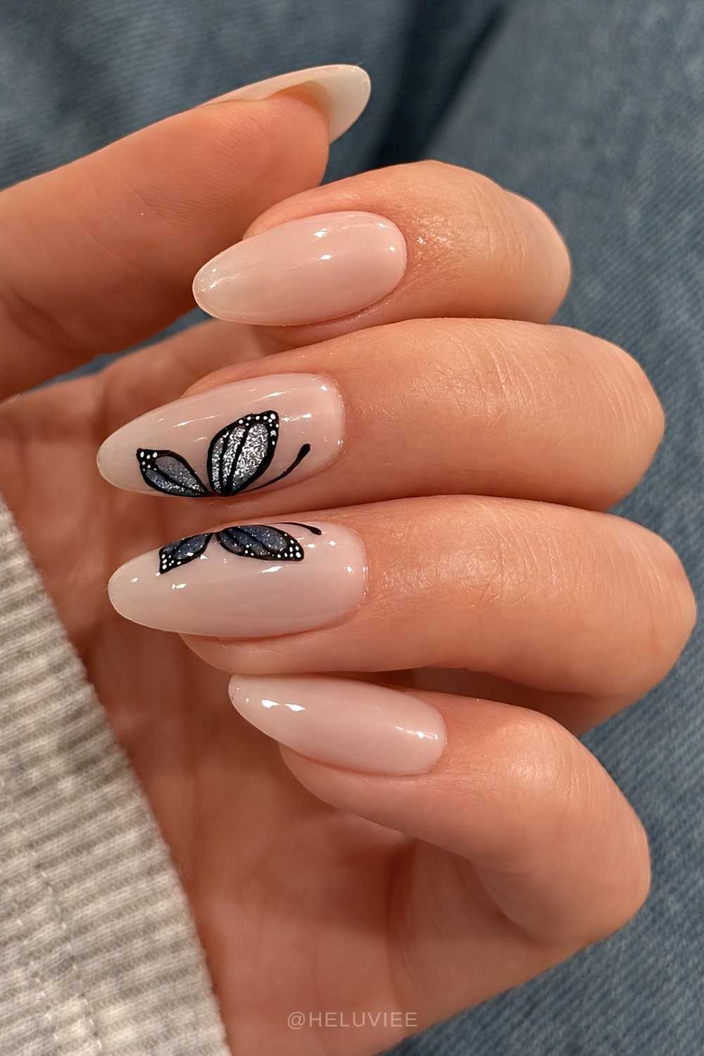 Milky manicure with glittery butterfly art