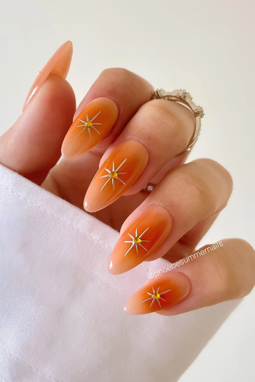 Orange aura nails with gold star accents