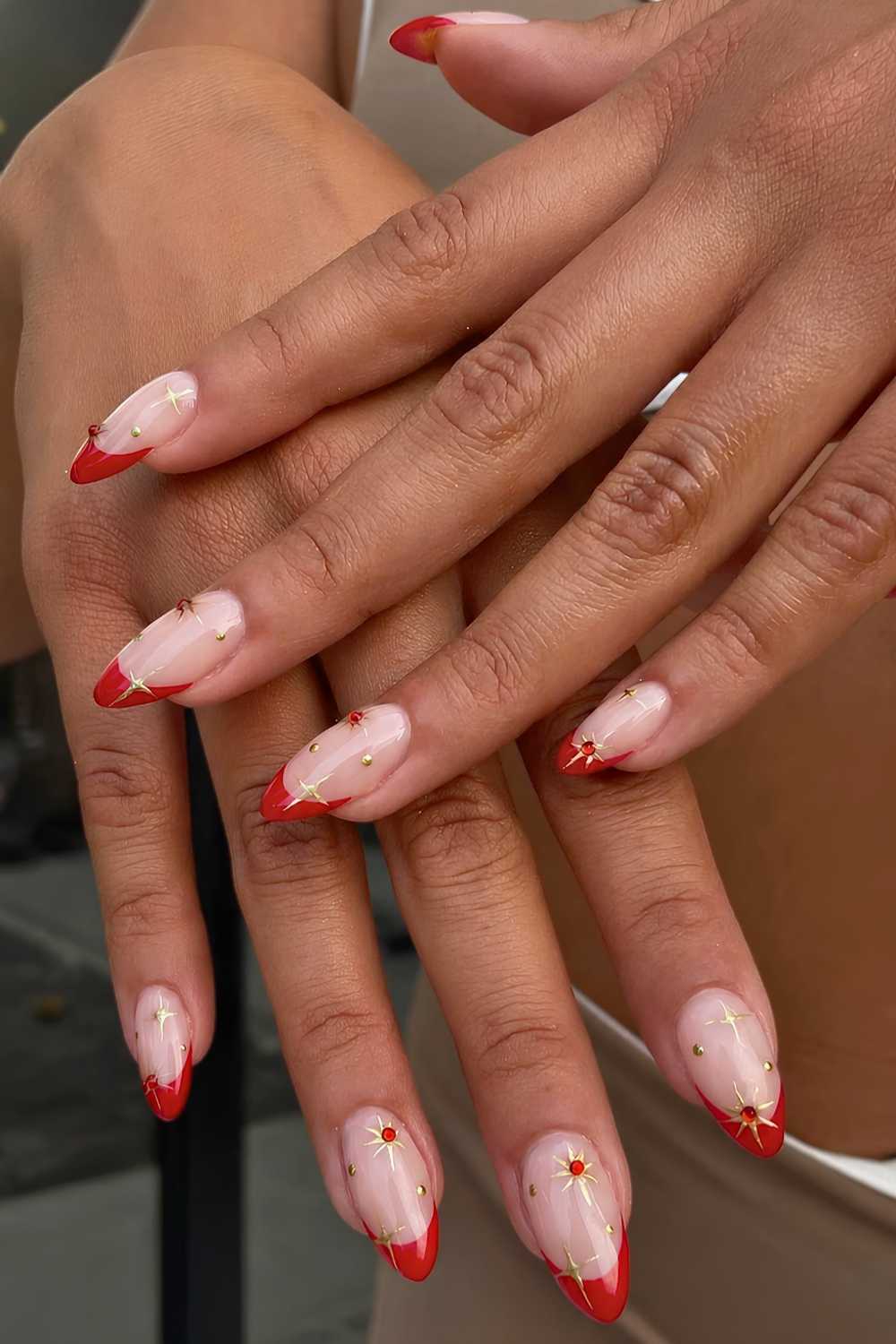 Red French mani with gold stars and gems