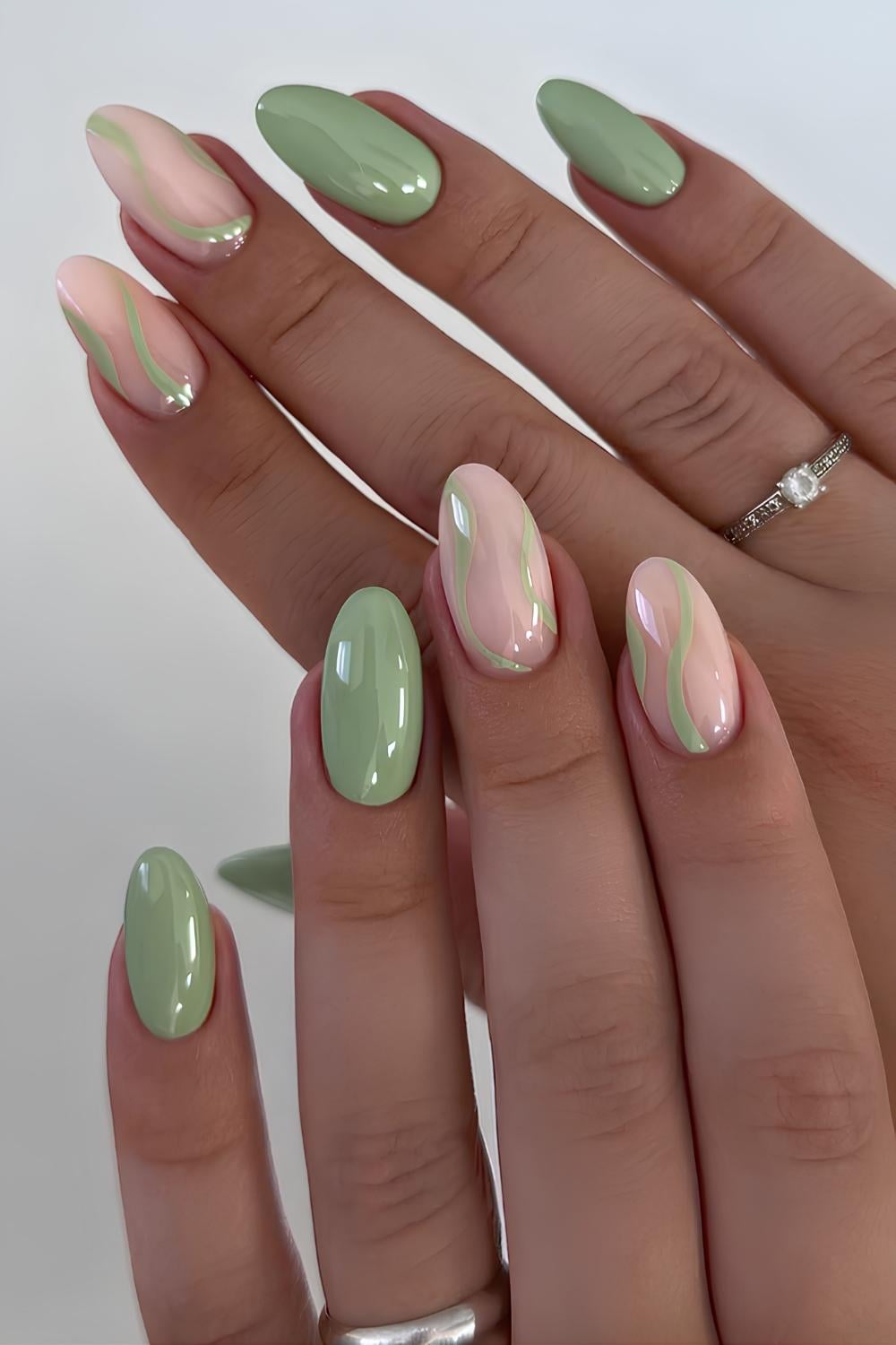 Sage green nails with accent swirl lines
